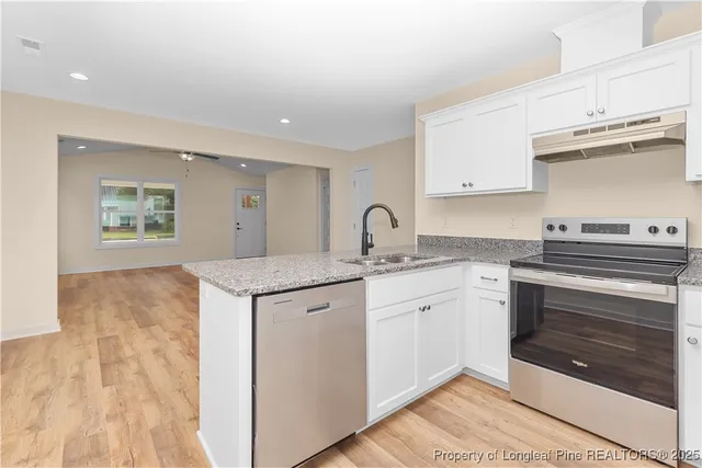 a kitchen with granite countertop a sink and cabinets