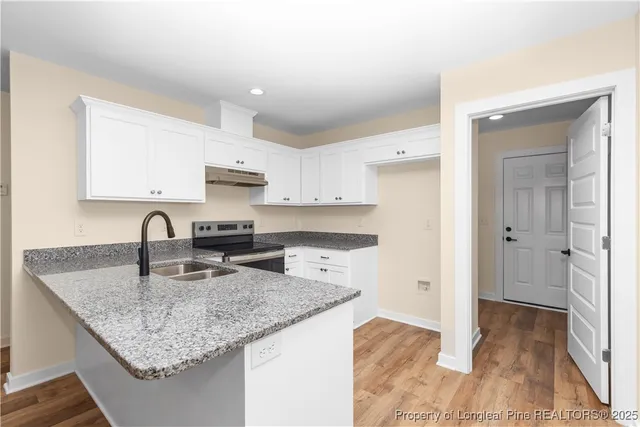 a kitchen with granite countertop kitchen island a sink appliances and cabinets