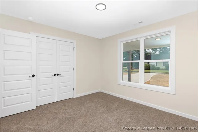 an empty room with windows and closet