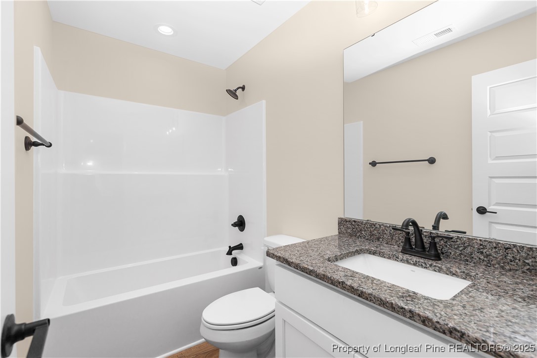 229 East Washington Street Coats, NC 27521 - Photo 22 of 24 a bathroom with a granite countertop sink toilet mirror and shower