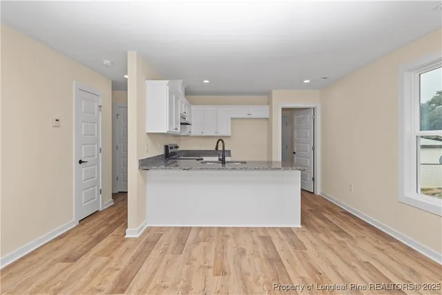a view of kitchen with stainless steel appliances granite countertop a stove a sink and a refrigerator