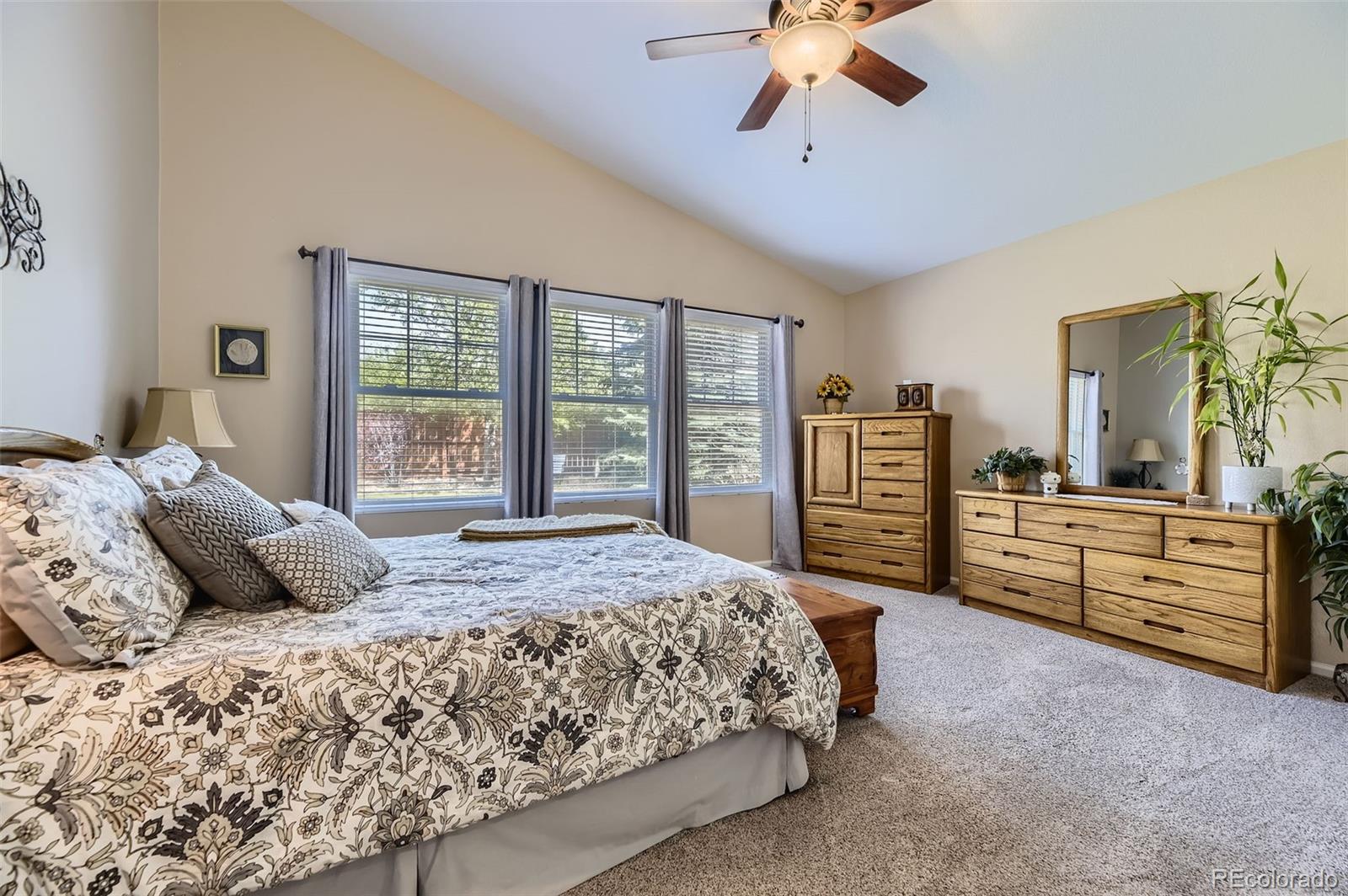 20040 East Doane Drive Aurora, CO 80013 - Photo 12 of 28 a bedroom with a large bed and a chandelier
