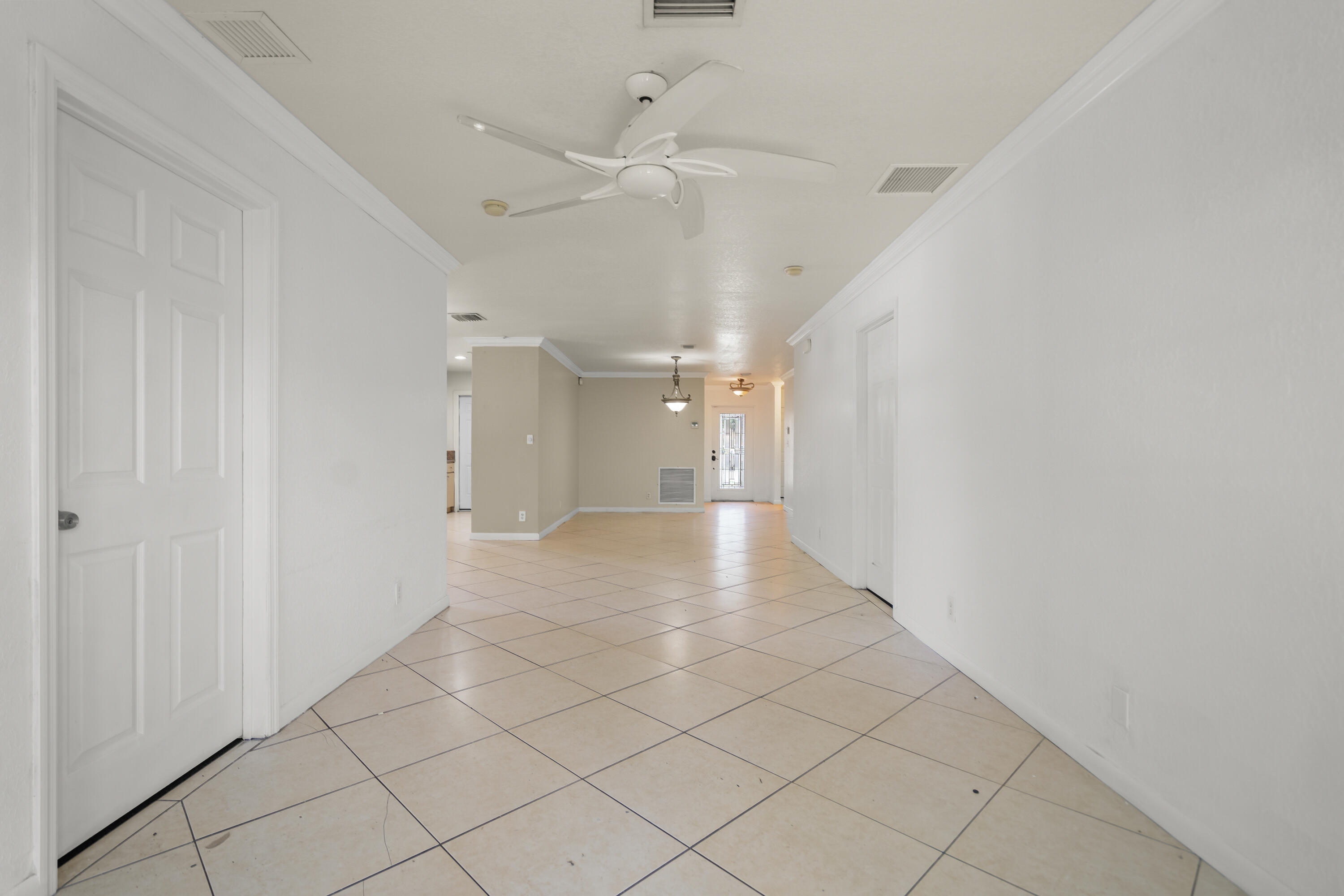 2241 Northwest 3rd Street Pompano Beach, FL 33069 - Photo 15 of 27 a view of a hallway with a chandelier fan and table