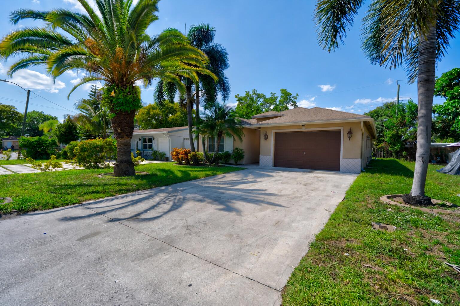 2241 Northwest 3rd Street Pompano Beach, FL 33069 - Photo 27 of 27 a front view of a house with a garden and a yard
