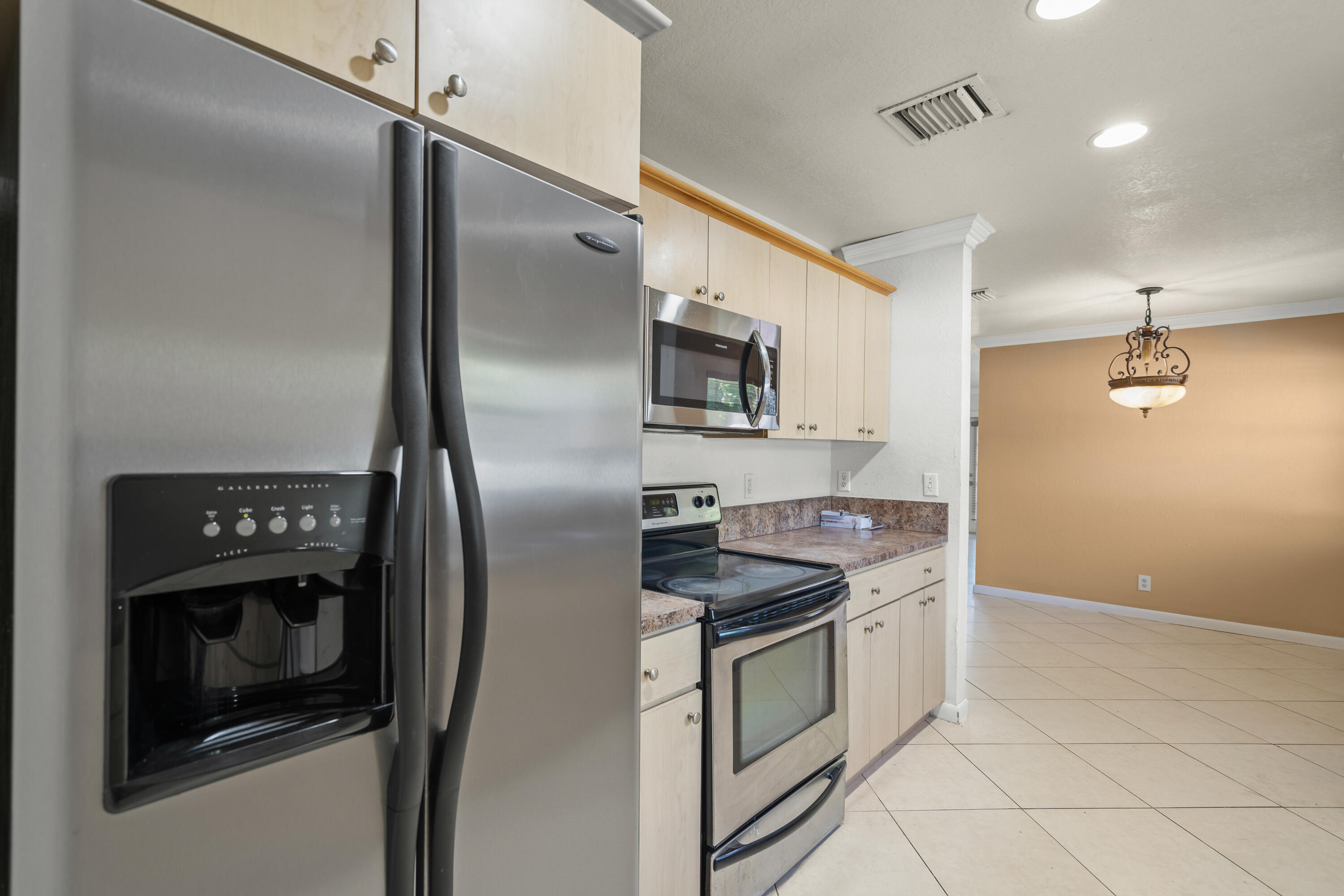 2241 Northwest 3rd Street Pompano Beach, FL 33069 - Photo 9 of 27 a kitchen with stainless steel appliances granite countertop a refrigerator a stove and a sink with wooden floor