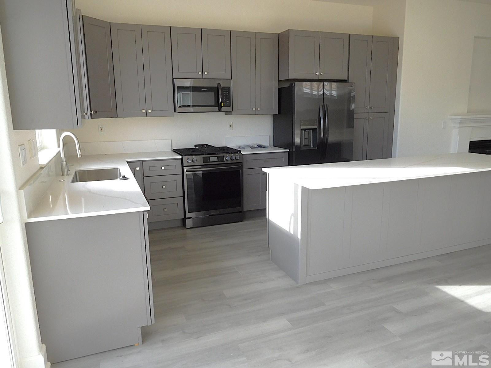 3463 Long Drive Minden, NV 89423 - Photo 8 of 36 a kitchen with stainless steel appliances a refrigerator stove and sink