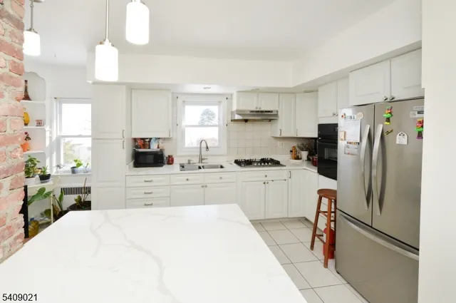 a kitchen with a refrigerator a stove a sink dishwasher a oven with cabinets and wooden floor