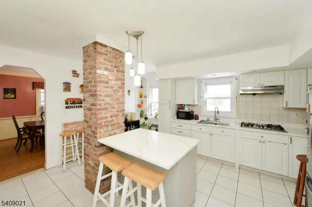 a kitchen with a stove a sink a counter top space and cabinets