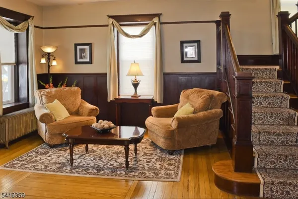 a view of a dining room with furniture a chandelier and wooden floor