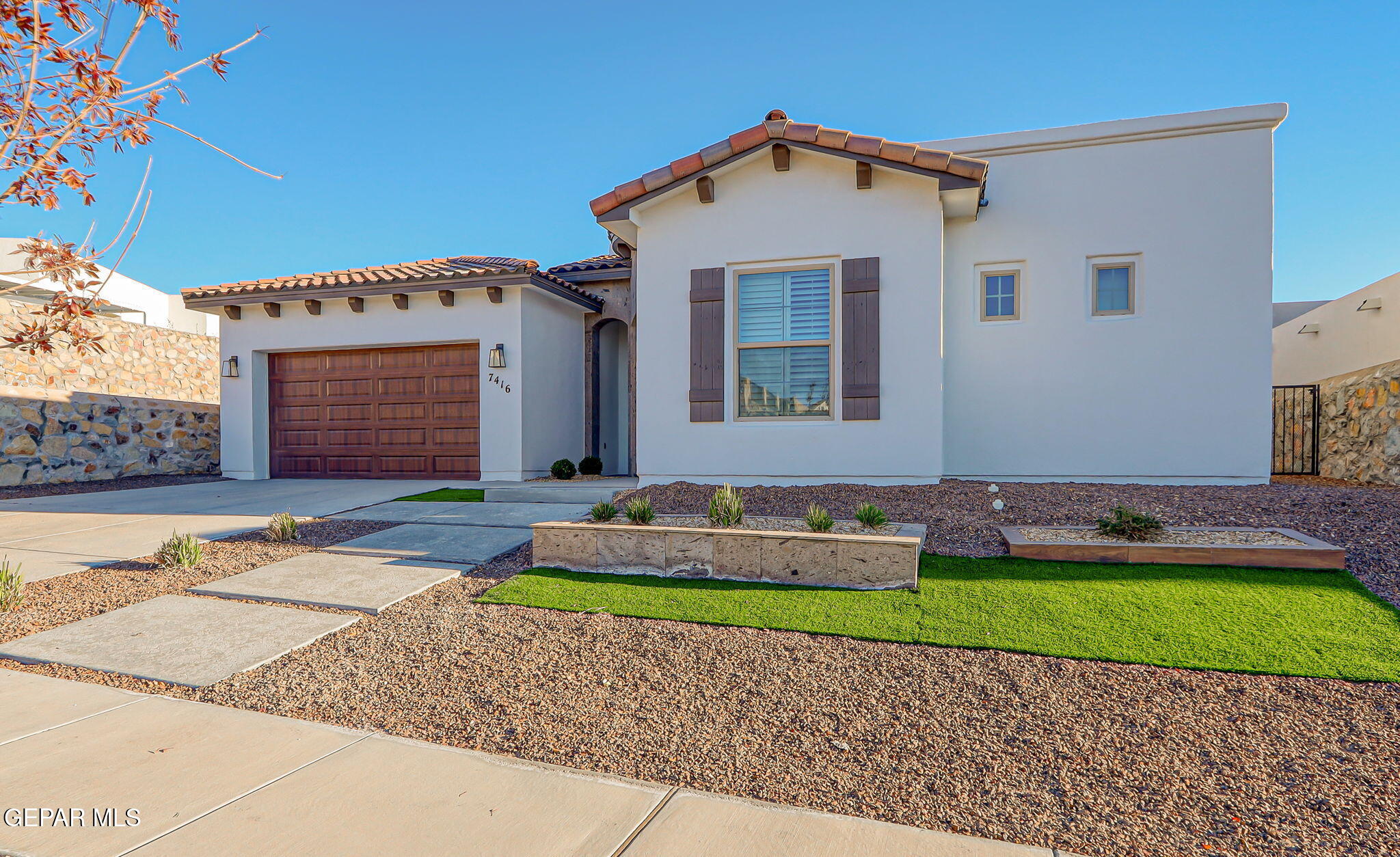 7416 Cimarron Rim Drive El Paso, TX 79911 - Photo 2 of 58 a front view of a house with a yard and garage