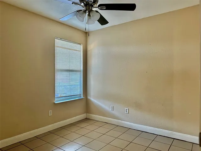 an empty room with windows and fan