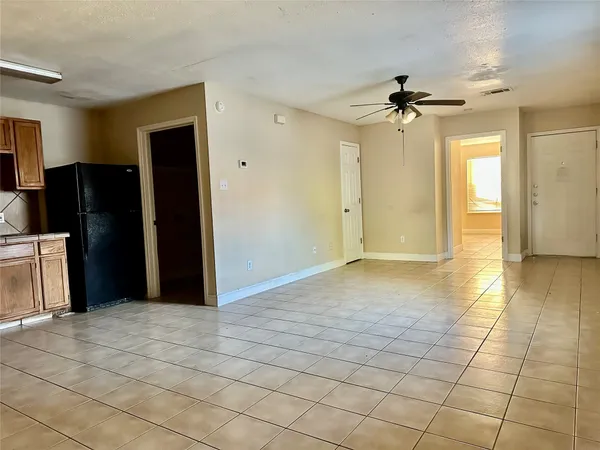 a view of a livingroom with a chandelier fan and windows