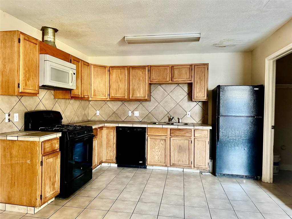 Undisclosed Address Austin, TX 78752 - Photo 4 of 15 a kitchen with granite countertop a refrigerator and a stove