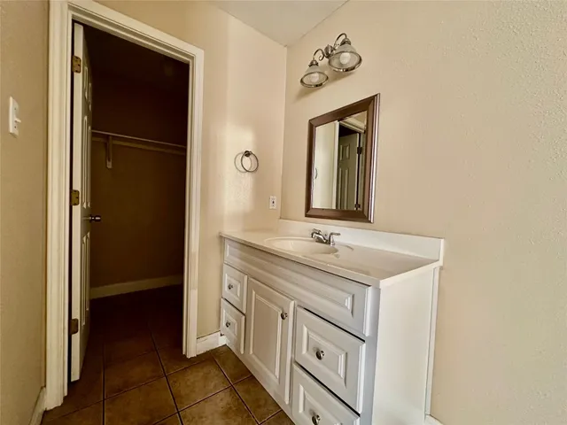 a bathroom with a sink a light fixture and a mirror