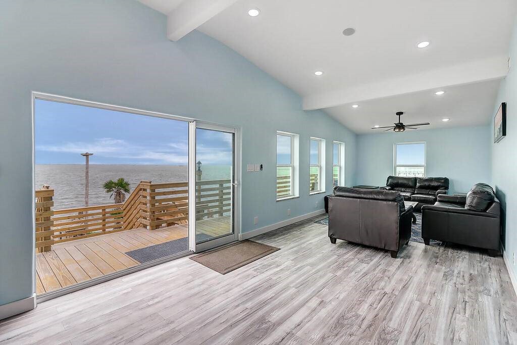 2445 Laguna Shores Road Corpus Christi, TX 78418 - Photo 15 of 39 a large living room with stainless steel appliances kitchen island granite countertop a large window and a wooden floors