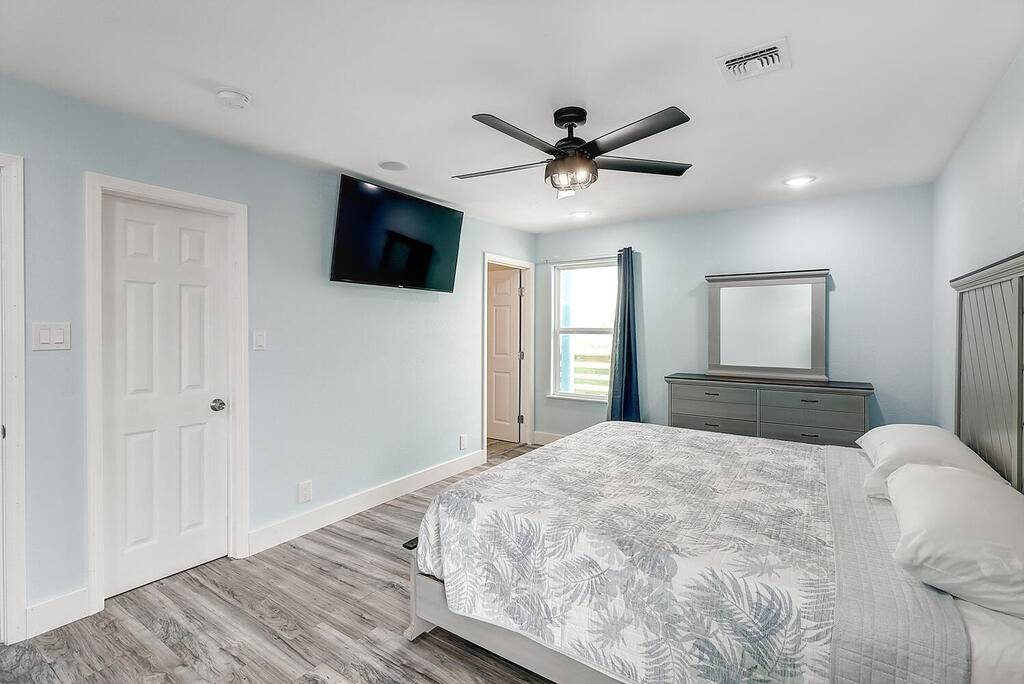 2445 Laguna Shores Road Corpus Christi, TX 78418 - Photo 24 of 39 a bedroom with a large bed and a flat screen tv