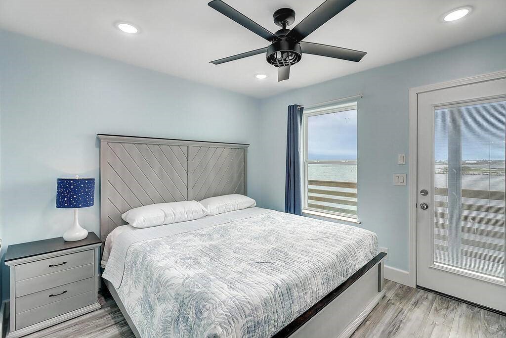 2445 Laguna Shores Road Corpus Christi, TX 78418 - Photo 29 of 39 a bedroom with a large bed and a chandelier