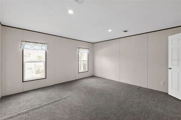 an empty room with windows and closet