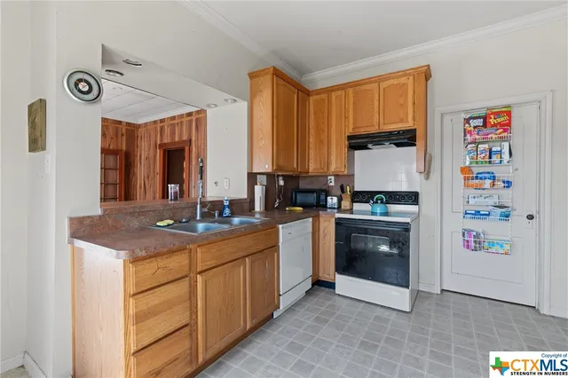 a kitchen with stainless steel appliances granite countertop a sink and a refrigerator