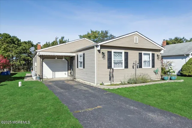 a front view of a house with a yard and trees