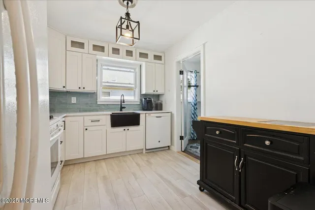 a kitchen with granite countertop a sink cabinets and stainless steel appliances