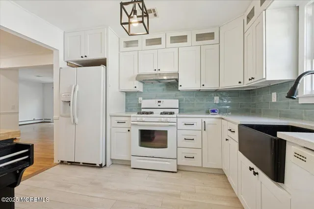 a kitchen with white cabinets and white appliances