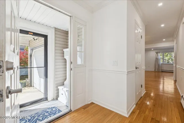 a view of a hallway with wooden floor and windows