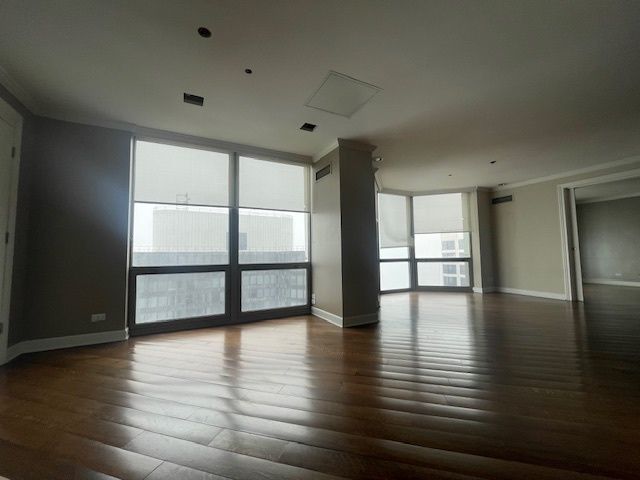 a view of an empty room with window and wooden floor