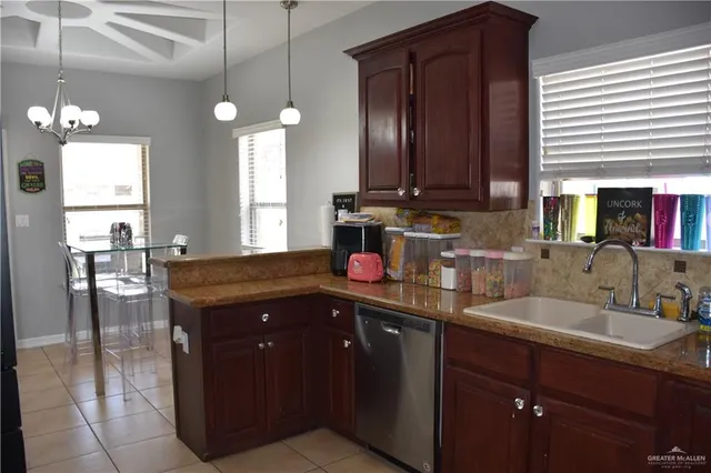 a kitchen with granite countertop stainless steel appliances wooden cabinet and stove top oven
