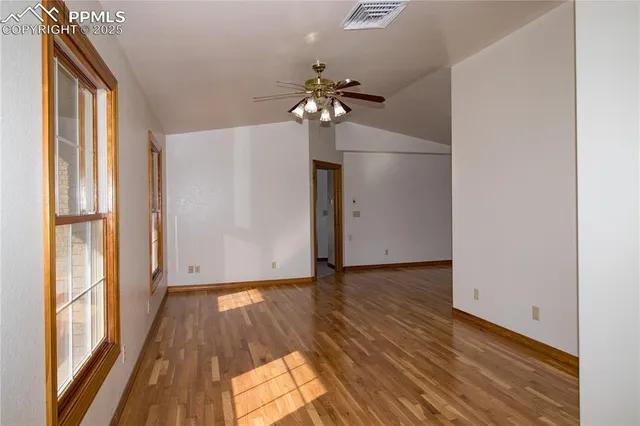 a view of a livingroom with wooden floor and a ceiling fan