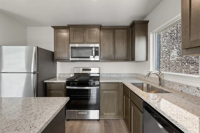a kitchen with a sink stove and refrigerator
