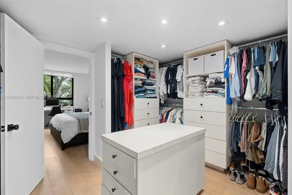a view of walk in closet with clothes and shoes
