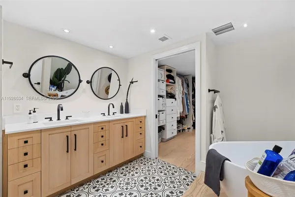 a bathroom with a double vanity sink a toilet and a mirror