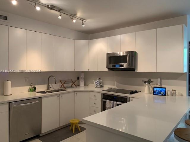 141 Crandon Boulevard, Unit 237 Key Biscayne, FL 33149 - Photo 31 of 38 a kitchen with a sink a microwave and cabinets