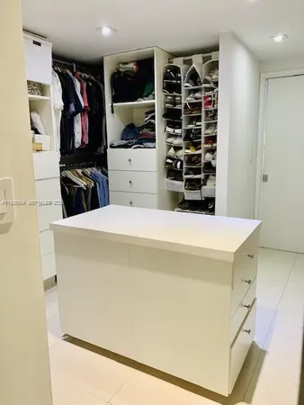 a view of walk in closet with clothes and shoes