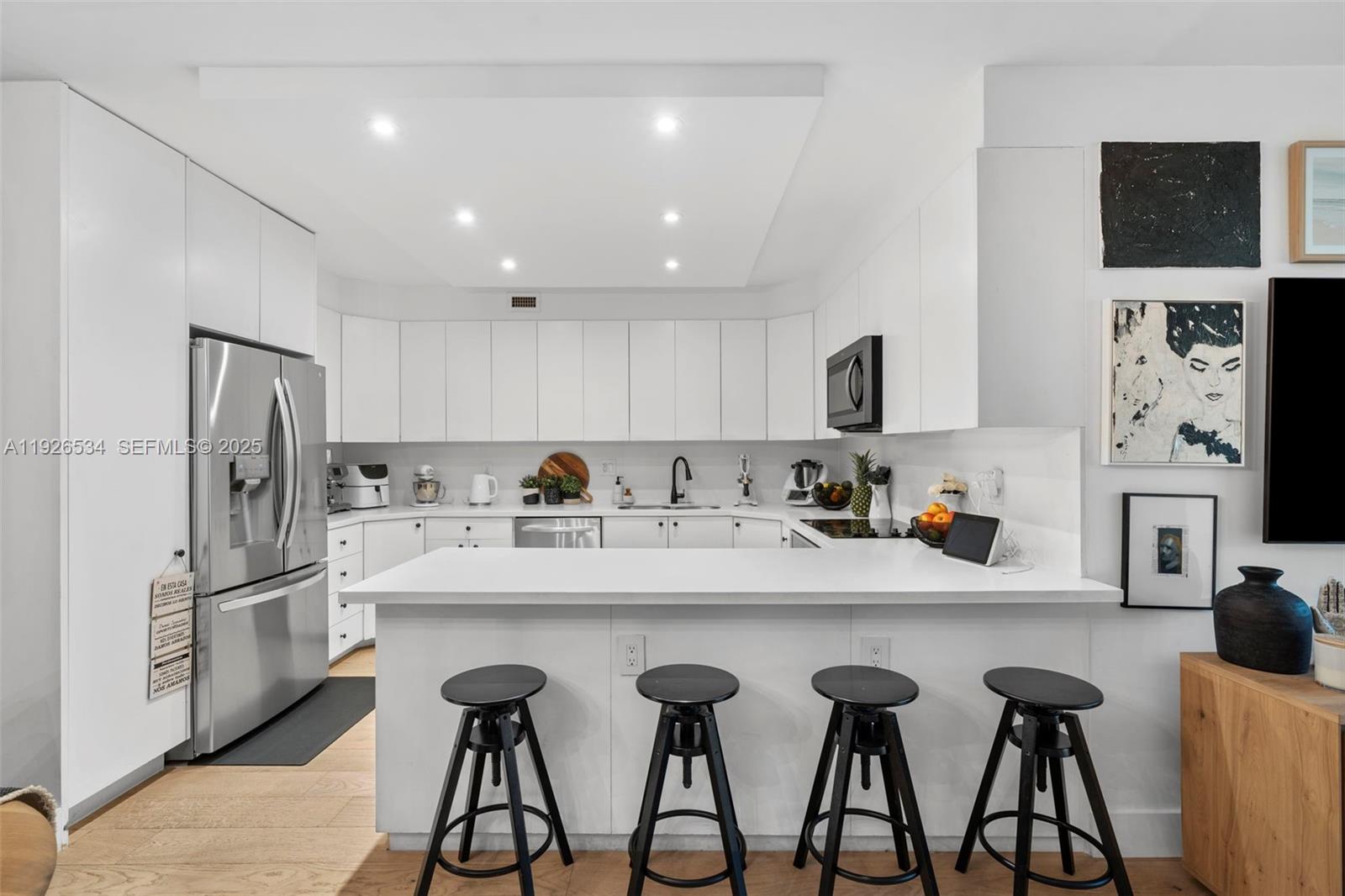 141 Crandon Boulevard, Unit 237 Key Biscayne, FL 33149 - Photo 5 of 38 a kitchen with refrigerator and cabinets