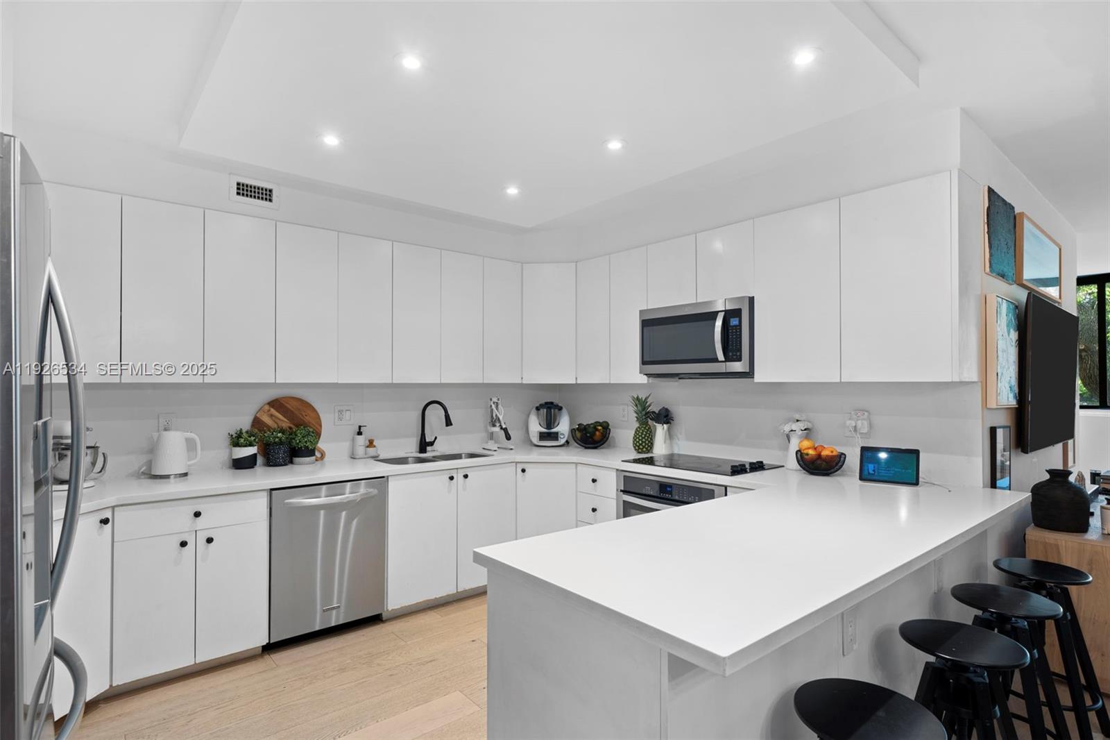 141 Crandon Boulevard, Unit 237 Key Biscayne, FL 33149 - Photo 6 of 38 a kitchen with a sink a stove and cabinets