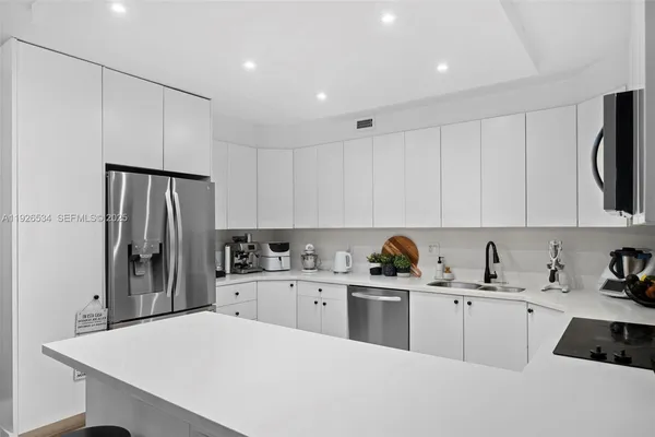 a kitchen with a sink a refrigerator and cabinets