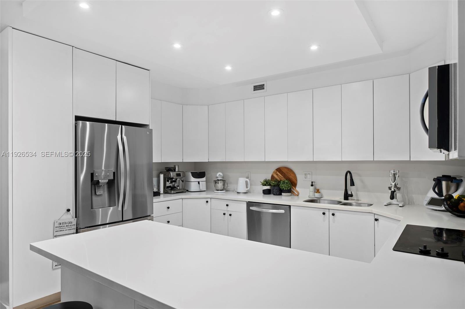 141 Crandon Boulevard, Unit 237 Key Biscayne, FL 33149 - Photo 7 of 38 a kitchen with a sink a refrigerator and cabinets