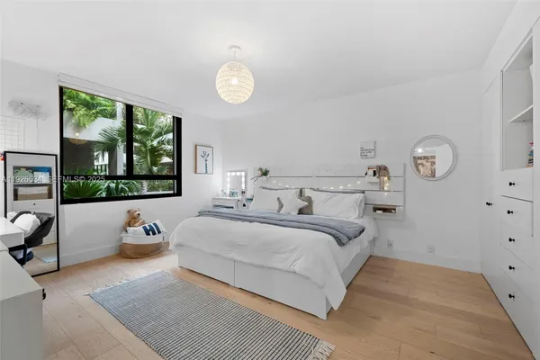 a bedroom with a bed and large windows