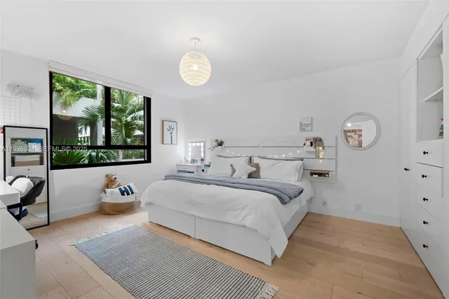 a bedroom with a bed and large windows