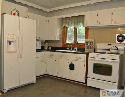 71 Middle Hill Road Colonia, NJ 07067 - Photo 3 of 10 a kitchen with stainless steel appliances white cabinets and a refrigerator