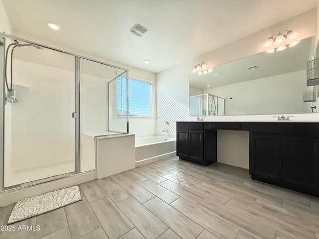 a large bathroom with a double vanity sink mirror and a bathtub