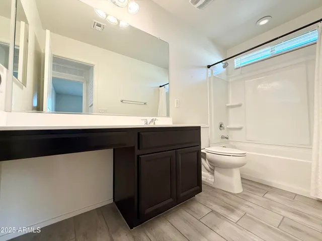 a bathroom with a sink a toilet a mirror and shower