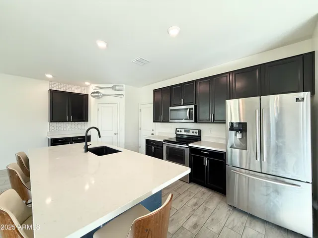 a kitchen with stainless steel appliances a refrigerator stove microwave and sink