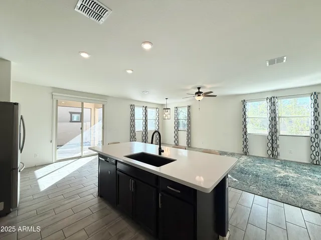 a kitchen with stainless steel appliances granite countertop a sink and a refrigerator