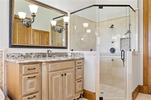 a bathroom with a granite countertop tub and a sink