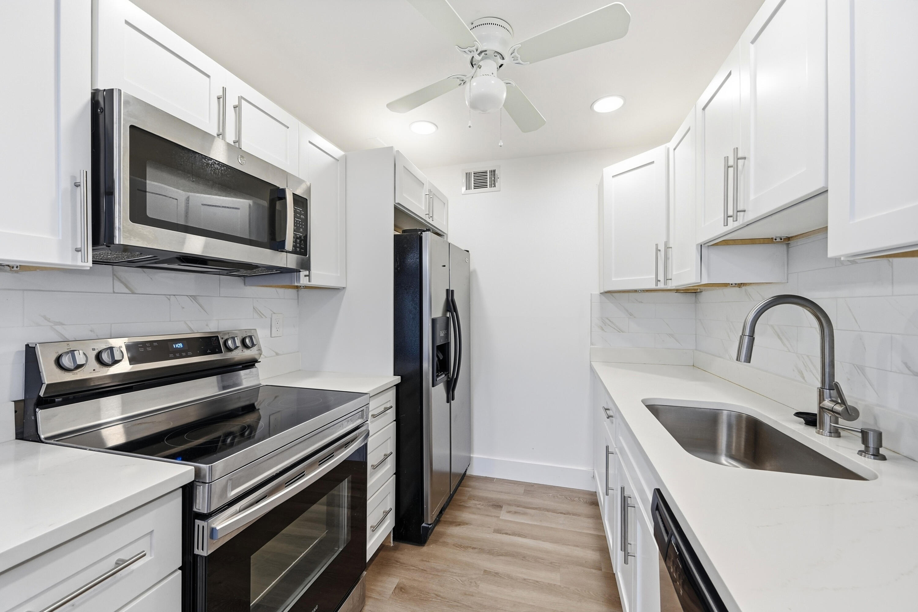 1043 Cornwall C Boca Raton, FL 33434 - Photo 8 of 34 a kitchen with stainless steel appliances a stove microwave and a sink
