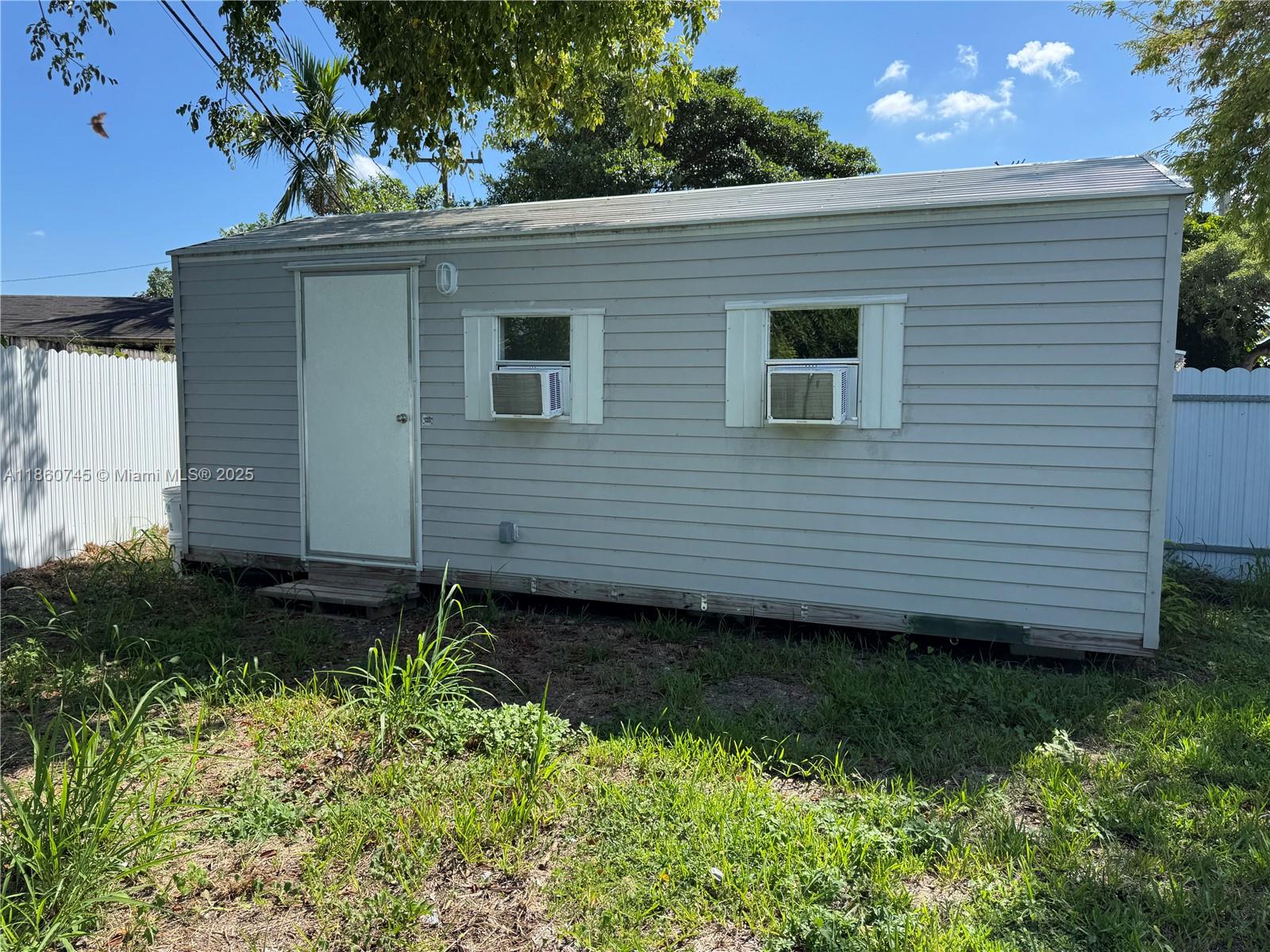 11751 Southwest 190th Terrace, Unit 1A Miami, FL 33177 - Photo 2 of 8 a view of a backyard with plants and large tree