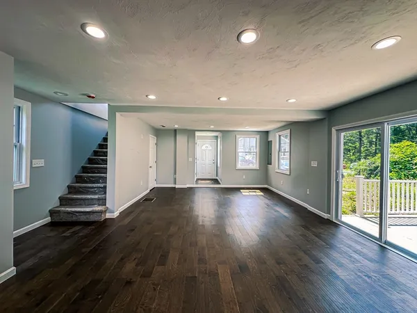 an empty room with wooden floors and windows